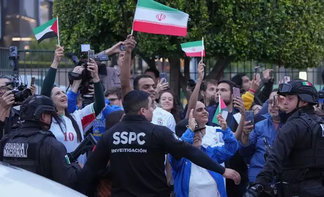Fans for team Iran wave as players arrive for the World Cup soccer tournament in Tijuana, Mexico, Sunday, June 7, 2026. (AP Photo/Gregory Bull)