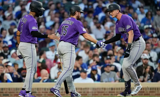 Colorado Rockies' TJ Rumfield, right, celebrates with Willi Castro, left, and Hunter Goodman after hitting a two-run home run during the fourth inning of a baseball game against the Chicago Cubs in Chicago, Tuesday, June 16, 2026. (AP Photo/Nam Y. Huh)