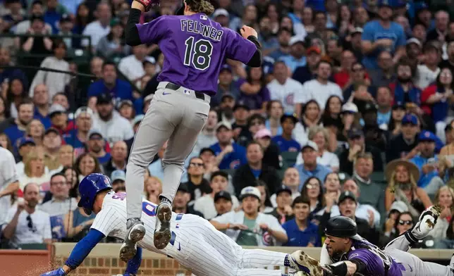 Chicago Cubs' Matt Shaw, bottom left, scores on a wild pitch by Colorado Rockies starting pitcher Ryan Feltner (18) as catcher Brett Sullivan, right, applies a late tag during the second inning of a baseball game in Chicago, Tuesday, June 16, 2026. (AP Photo/Nam Y. Huh)