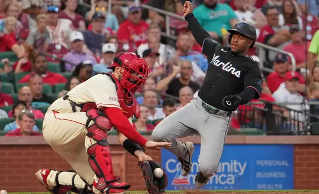 Miami Marlins' Xavier Edwards, right, scores past St. Louis Cardinals catcher Jimmy Crooks during the seventh inning of a baseball game Saturday, June 27, 2026, in St. Louis. (AP Photo/Jeff Roberson)