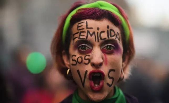 A demonstrator poses for a photo with her face painted in Spanish, "The femicide-committer is you" during a march marking the anniversary of the "Ni Una Menos" (Not One Fewer) women's movement in Buenos Aires, Argentina, Wednesday, June 3, 2026. (AP Photo/Natacha Pisarenko)