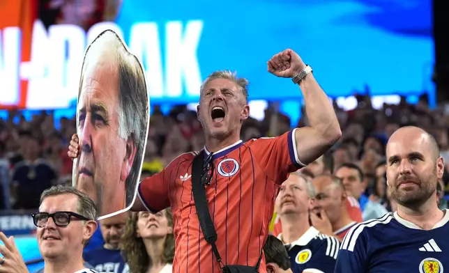 A Scotland fan cheers while holding a photo of Bill Belichick during the World Cup Group C soccer match between Haiti and Scotland in Foxborough, Mass., near Boston, Saturday, June 13, 2026. (AP Photo/Charlie Krupa)