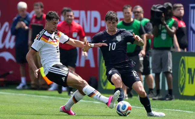 Germany midfielder Aleksandar Pavlović, left, tackles the ball from United States forward Christian Pulisic during the first half of an international friendly soccer match in Chicago, Saturday, June 6, 2026. (AP Photo/Nam Y. Huh)