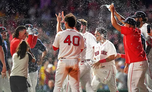 Boston Red Sox's Jarren Duran, left, celebrates with teammates after hitting a walk-off one-run single in the tenth inning of a baseball game to win against the New York Yankees, Sunday, June 28, 2026, in Boston. (AP Photo/Steven Senne)