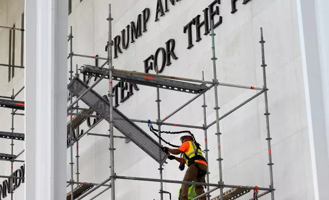 Workers erect scaffolding in front of the John F. Kennedy Center for the Performing Arts sign in Washington, Friday, June 12, 2026. (AP Photo/Cliff Owen)