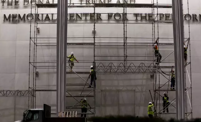 Workers construct scaffolding below the sign for the John F. Kennedy Center for the Performing Arts, Friday, June 12, 2026, in Washington. (AP Photo/Rahmat Gul)