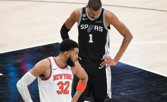 San Antonio Spurs forward Victor Wembanyama (1) looks down as New York Knicks center Karl-Anthony Towns (32) looks towards his bench during the second half of Game 1 of the NBA Finals basketball series, Wednesday, June 3, 2026, in San Antonio. (AP Photo/Eric Gay)