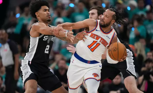 New York Knicks guard Jalen Brunson (11) is pressured by San Antonio Spurs guard Dylan Harper (2) during the first half of Game 1 of the NBA Finals basketball series, Wednesday, June 3, 2026, in San Antonio. (AP Photo/Eric Gay)