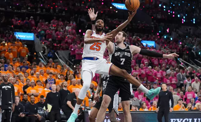 New York Knicks guard Mikal Bridges (25) shoots past San Antonio Spurs center Luke Kornet (7) during the second half of Game 1 of the NBA Finals basketball series, Wednesday, June 3, 2026, in San Antonio. (AP Photo/Eric Gay)