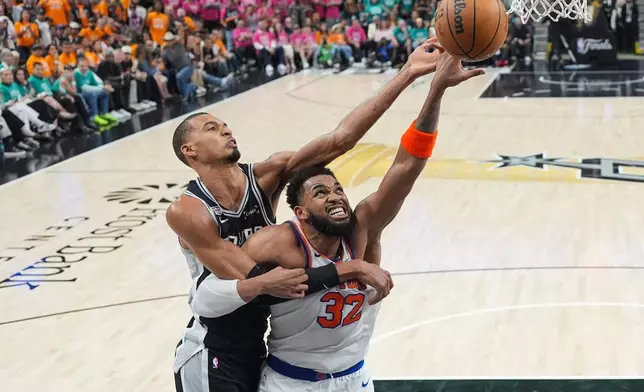 San Antonio Spurs forward Victor Wembanyama and New York Knicks center Karl-Anthony Towns (32) battle for the rebound during the second half of Game 1 of the NBA Finals basketball series, Wednesday, June 3, 2026, in San Antonio. (AP Photo/Eric Gay)