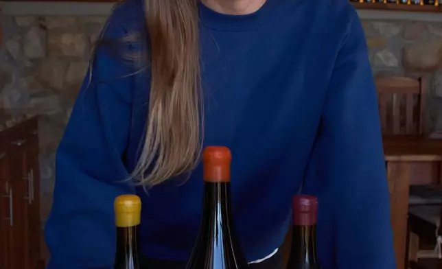 Natasha Jacka stands with some of her wines in Cape Town, South Africa, Thursday, June 4, 2026. (AP Photo/Neil Shaw)