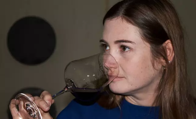 Natasha Jacka evaluates a glass of wine during the period it matures in oak in Cape Town, South Africa, Thursday, June 4, 2026. (AP Photo/Neil Shaw)