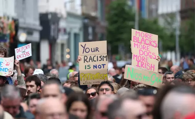 People gather during an anti-racism rally outside Belfast City Hall sparked by a knife attack on a man in north Belfast on Monday, in Belfast, Saturday June 13, 2026. (Peter Morrison/PA via AP)