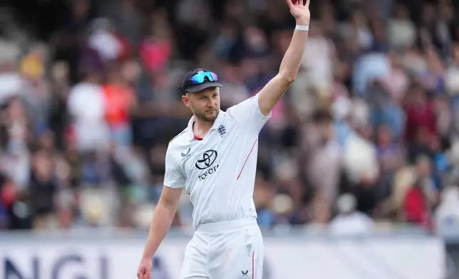England's Gus Atkinson holds the ball as he leaves the field after bowling out New Zealand's Matt Henry to win the Test match between England and New Zealand at Lord's cricket ground in London, Sunday, June 7, 2026. (AP Photo/Kirsty Wigglesworth)