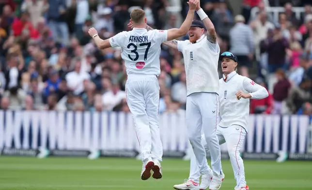 England's Gus Atkinson, left, celebrates with captain Ben Stokes after bowling out New Zealand's Matt Henry to win the Test match between England and New Zealand at Lord's cricket ground in London, Sunday, June 7, 2026. (AP Photo/Kirsty Wigglesworth)