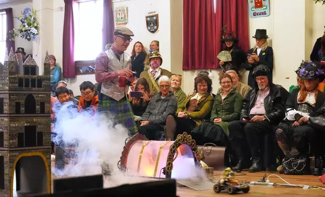 Lukas Hazlehurst drives a remote-controlled vehicle around an obstacle course during a teapot racing contest at the Steampunk NZ Festival in Ōamaru, New Zealand, Saturday, May 30, 2026. (AP Photo/Charlotte Graham-McLay)