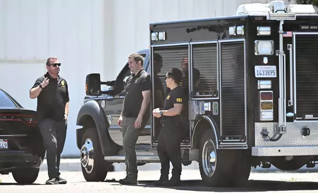 FBI agents stage at GKN Aerospace in Garden Grove, Calif. on Wednesday, June 10, 2026. (AP Photo/William Liang)