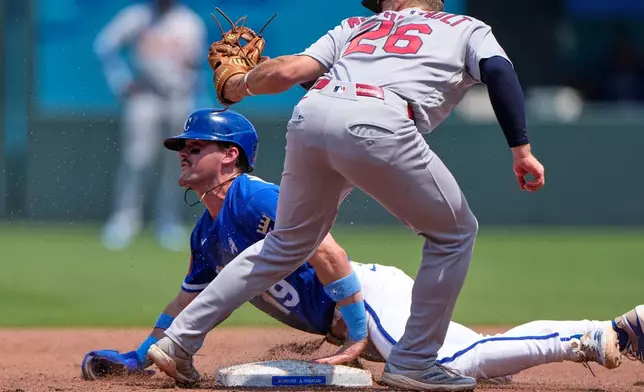Kansas City Royals' Michael Massey (19) beats the tag by St. Louis Cardinals second baseman JJ Wetherholt to steal second during the third inning of a baseball game Sunday, June 21, 2026, in Kansas City, Mo. (AP Photo/Charlie Riedel)