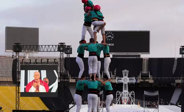Performers make a human tower, known as Castells, for Pope Leo XIV as he leads a vigil of prayer at the Lluis Companys Olympic Stadium, in Barcelona, Tuesday, June 9, 2026. (AP Photo/Alessandra Tarantino)