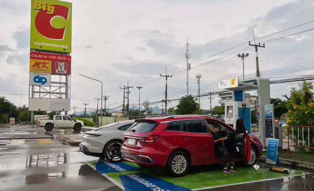 Chanakan Sa-Nguanslip waits for her Chinese-made electric vehicle to charge at a gas station in Kanchanaburi, Thailand on May 30, 2026. (AP Photo/Anton L. Delgado)