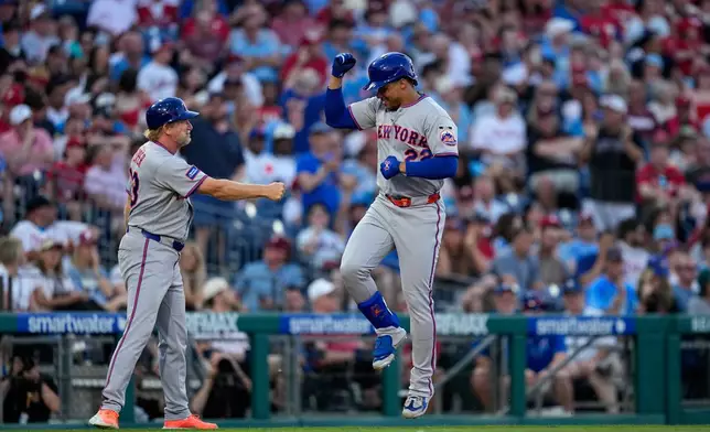 New York Mets' Juan Soto, right, celebrates with third base coach Tim Leiper after hitting a home run against Philadelphia Phillies pitcher Aaron Nola during the third inning of a baseball game Thursday, June 18, 2026, in Philadelphia. (AP Photo/Matt Slocum)
