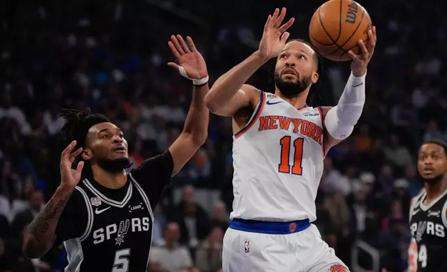New York Knicks guard Jalen Brunson (11) shoots past San Antonio Spurs guard Stephon Castle during first half of Game 4 of the NBA Finals basketball series, Wednesday, June 10, 2026, in New York. (AP Photo/Ross D. Franklin)