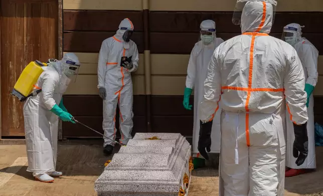 Health workers prepare the coffin of Angèle Muyumba Nsimire, a university student who died of Ebola at the Citadelle Clinic in Bunia, Congo, Friday, June 12, 2026. (AP Photo/Moses Sawasawa)