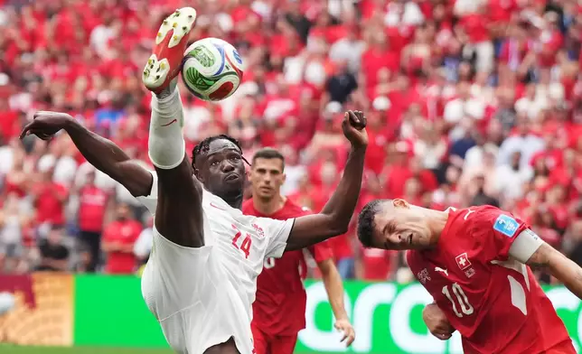 Canada's Promise David (24) takes a shot on goal as Switzerland's Granit Xhaka (10) defends during the World Cup Group B soccer match between Switzerland and Canada in Vancouver, British Columbia, Wednesday, June 24, 2026. (Darryl Dyck/The Canadian Press via AP)