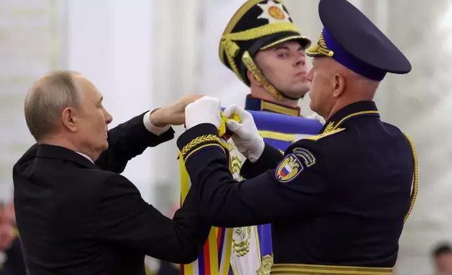 Russian President Vladimir Putin, left, and Commander of the Presidential Regiment Maj. Gen. Mikhail Suraikin, right, attend a ceremony to present the Order of Zhukov to the Presidential Regiment of the Russian Federal Guard Service at the Kremlin's St. George Hall in Moscow, Tuesday, June 23, 2026. (Mikhail Metzel/Sputnik, Kremlin Pool Photo via AP)