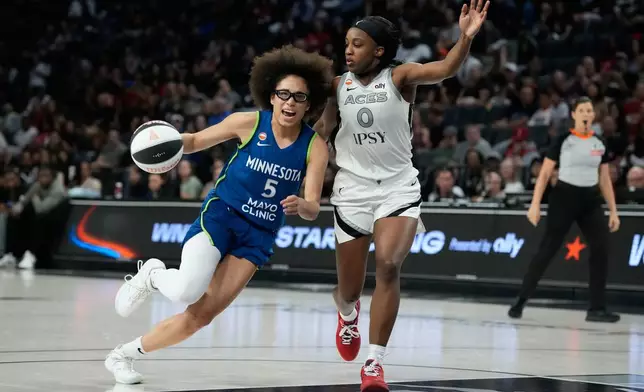 Minnesota Lynx guard Olivia Miles (5) drives against Las Vegas Aces guard Jackie Young (0) during the second half of a WNBA basketball game Saturday, June 13, 2026, in Las Vegas. (AP Photo/John Locher)