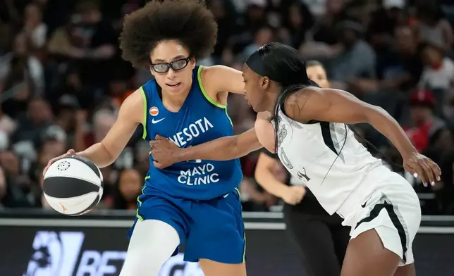 Minnesota Lynx guard Olivia Miles (5) drives against Las Vegas Aces guard Jackie Young (0) during the second half of a WNBA basketball game Saturday, June 13, 2026, in Las Vegas. (AP Photo/John Locher)