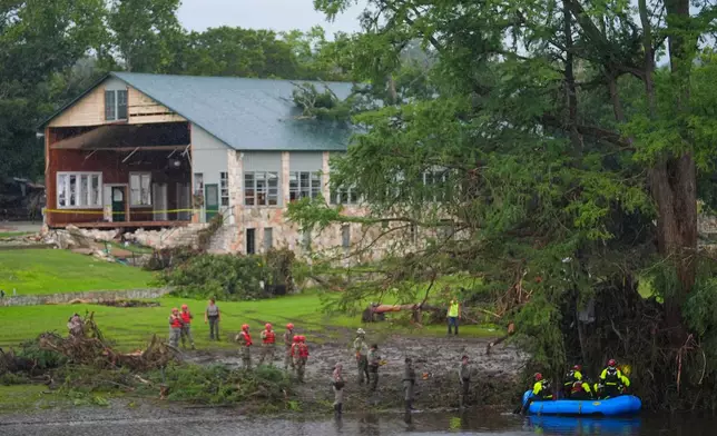 FILE - Rescue workers are seen on land and on a boat as they search for missing people near Camp Mystic along the Guadalupe River after a flash flood swept through the area Sunday, July 6, 2025, in Hunt, Texas. (AP Photo/Julio Cortez, File)