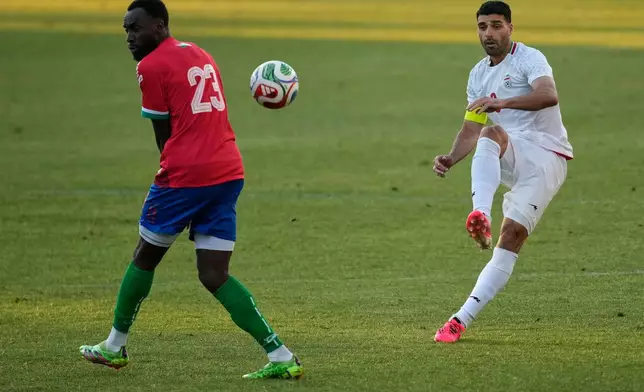 Iran's Mehdi Taremi, right, shoots the ball next to Gambia's Mouhamadou Drammeh during a friendly soccer match between Iran and Gambia, in Antalya, southern Turkey, Friday, May 29, 2026. (AP Photo/Khalil Hamra)