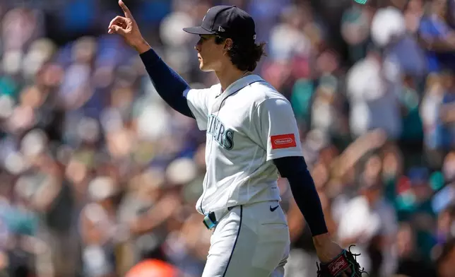 Seattle Mariners starting pitcher Bryan Woo reacts to fans as he walks to the dugout after being relieved during the eighth inning of a baseball game against the Baltimore Orioles, Thursday, June 18, 2026, in Seattle. (AP Photo/Lindsey Wasson)