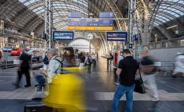 Travelers are on the move at the main train station in Frankfurt, Germany early Wednesday, June 24, 2026. (Andreas Arnold/dpa via AP)