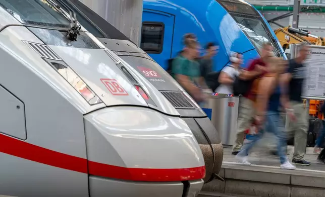 Passengers walk through Munich Central Station to catch their trains this morning following the nationwide Deutsche Bahn service disruption Wednesday, June 24, 2026. (Peter Kneffel/dpa via AP)