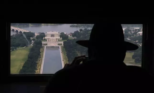 David Boczar photographs the Lincoln Memorial and the Lincoln Memorial Reflecting Pool from a window at the top of the Washington Monument, Friday, June 26, 2026, in Washington. (AP Photo/Carolyn Kaster)