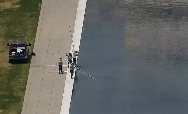 Personnel work on the Lincoln Memorial Reflecting Pool near the base of the Lincoln Memorial, Friday, June 26, 2026, in Washington. (AP Photo/Carolyn Kaster)
