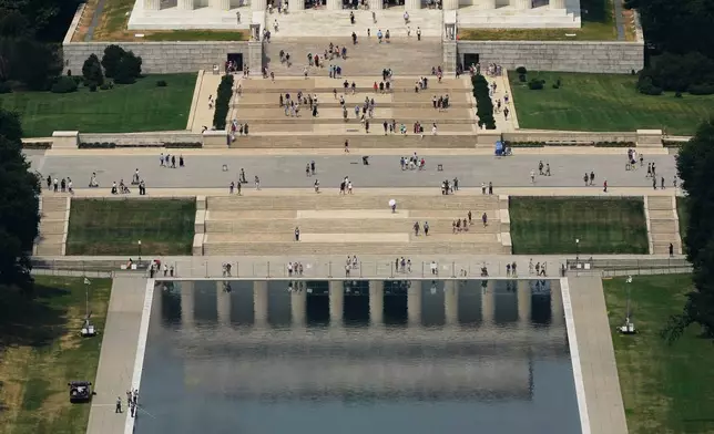 People, lower left, work on the Lincoln Memorial Reflecting Pool near the base of the Lincoln Memorial, Friday, June 26, 2026, in Washington. (AP Photo/Carolyn Kaster)