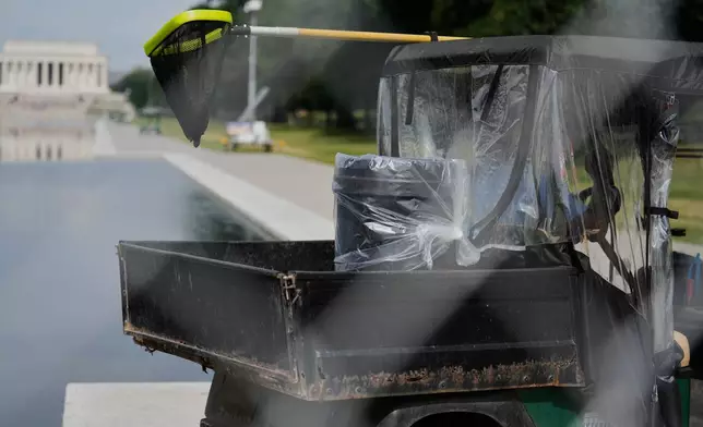 A maintenance vehicle carrying a pool skimmer net in the back moves along the Lincoln Memorial Reflecting Pool Friday, June 26, 2026, in Washington. (AP Photo/Carolyn Kaster)