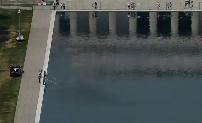 Personnel, lower left, work on the Lincoln Memorial Reflecting Pool near the base of the Lincoln Memorial, Friday, June 26, 2026, in Washington. (AP Photo/Carolyn Kaster)