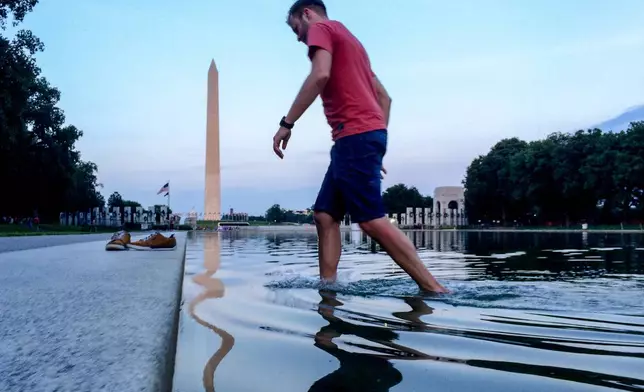 FILE - Martin Zich, of Prague, Czech Republic, wades out of the Reflecting Pool on the National Mall in Washington after going in to take photographs, May 31, 2016. (AP Photo/Andrew Harnik, File)