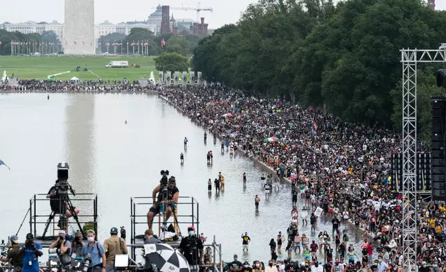 FILE - People wade in the Reflecting Pool during the March on Washington, Aug. 28, 2020, at the Lincoln Memorial in Washington, on the 57th anniversary of the Rev. Martin Luther King Jr.'s "I Have A Dream" speech. (AP Photo/Alex Brandon, File)