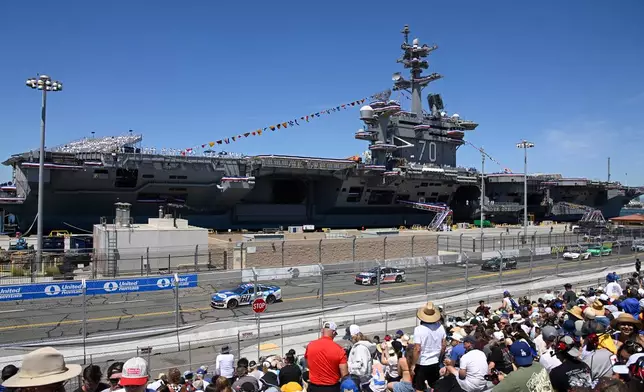 Cars race past the USS Carl Vinson during a NASCAR Cup Series auto race, Sunday, June 21, 2026, in Coronado, Calif. (AP Photo/Denis Poroy)