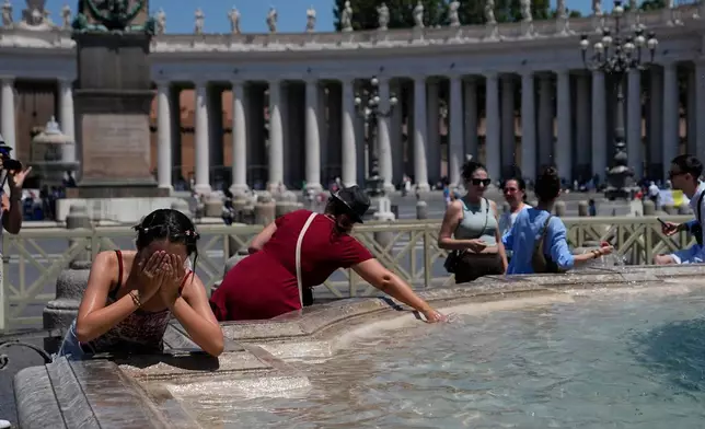People refresh in a fountain after the Angelus noon prayer celebrated by Pope Leo XIV from the window of his studio overlooking St.Peter's Square, at the Vatican, Sunday, June 28, 2026. (AP Photo/Alessandra Tarantino)