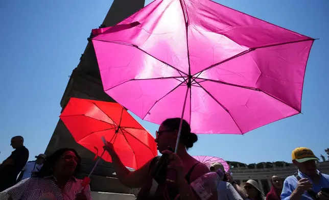 People shelter from sun with umbrellas as they wait for the Angelus noon prayer celebrated by Pope Leo XIV from the window of his studio overlooking St.Peter's Square, at the Vatican, Sunday, June 28, 2026. (AP Photo/Alessandra Tarantino)