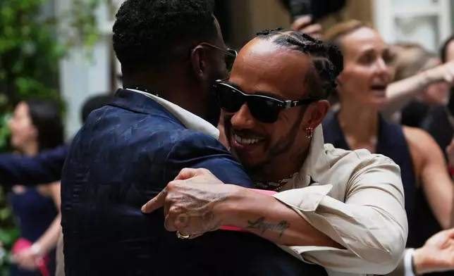Lewis Hamilton, right hugs Colman Domingo as he arrives for the Ralph Lauren Spring/Summer 2027 men's collection, presented in Milan, Italy, Friday, June 19, 2026. (AP Photo/Antonio Calanni)