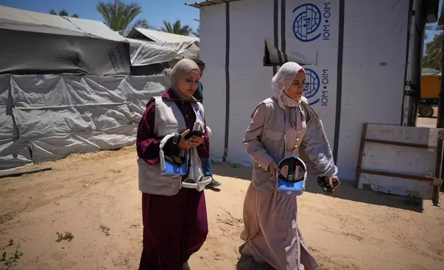 Mental health professionals arrive at a tent carrying virtual reality headsets to begin therapy sessions in Zawaida, central Gaza Strip, Wednesday, June 17, 2026. (AP Photo/Abdel Kareem Hana)