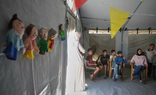 Palestinian children wait to receive a virtual reality psychosocial support session from a medical technology team in Zawaida, central Gaza Strip, Wednesday, June 17, 2026. (AP Photo/Abdel Kareem Hana)