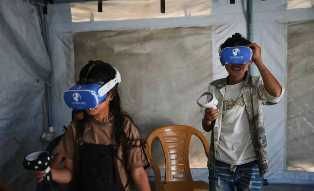 Palestinian children participate in a psychological support session using a virtual reality headset in a tent operated by a medical technology team in Zawaida, central Gaza Strip, Wednesday, June 17, 2026. (AP Photo/Abdel Kareem Hana)
